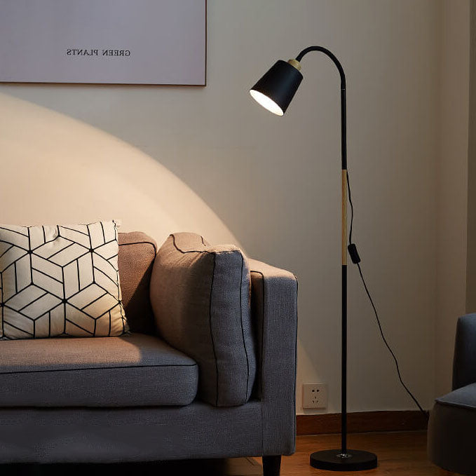 Schwarze Stehlampe mit Holzakzent in warm beleuchtetem Wohnzimmer