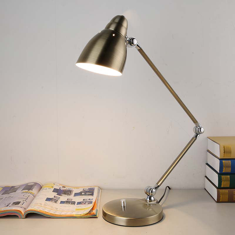 Silbern verchromte Architektenlampe auf hellem Holzschreibtisch mit Notizbüchern