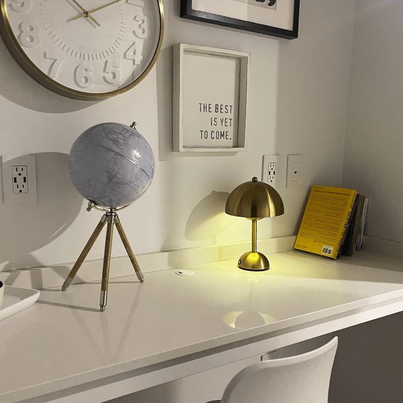 Graublaue Retro-Lampe auf weißem Tisch vor Wanduhr