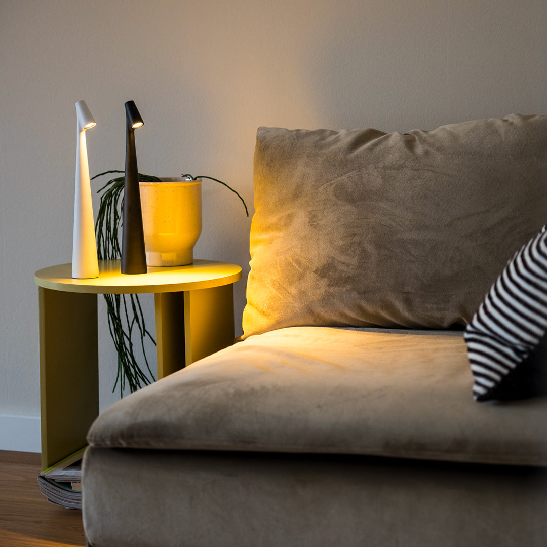 Gelbe LED-Tischlampe auf Couchtisch neben beigem Sofa