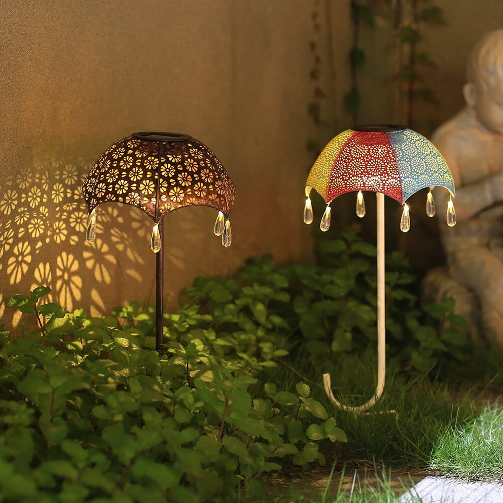 Leuchtende Solarleuchten in Regenschirmform auf Gartenweg mit Schattenmuster