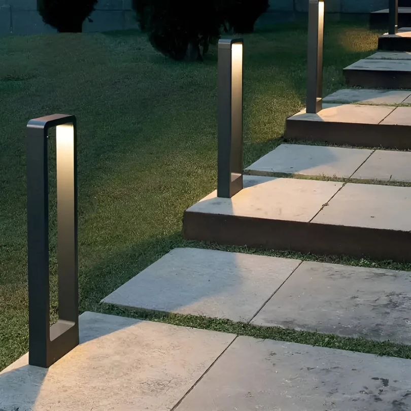 Mehrere schwarze Gartenleuchten mit integriertem Licht entlang Treppenweg
