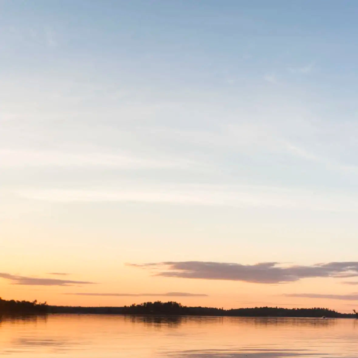 Sandsberg | Boot und Paddel an einem ruhigen See bei Sonnenuntergang Wandkunst