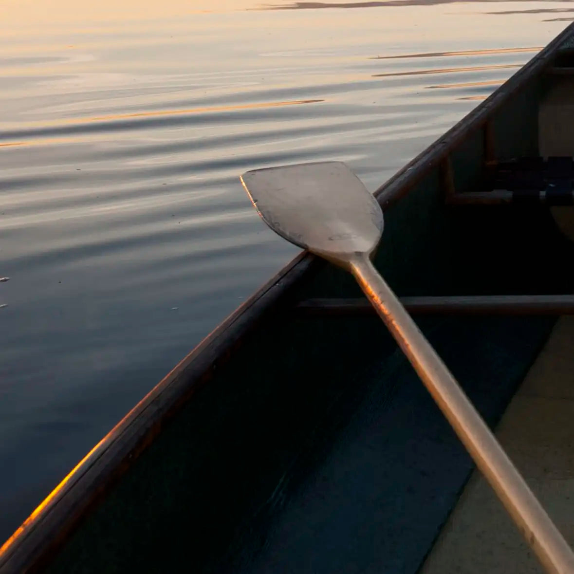 Sandsberg | Boot und Paddel an einem ruhigen See bei Sonnenuntergang Wandkunst