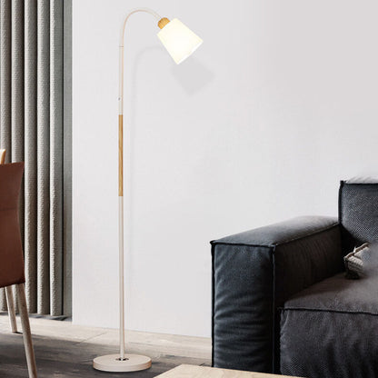 Weiße Stehlampe mit Holzdetail neben schwarzem Sofa und hellgrauen Vorhängen