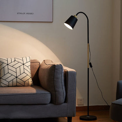 Schwarze Stehlampe mit Holzakzent in warm beleuchtetem Wohnzimmer