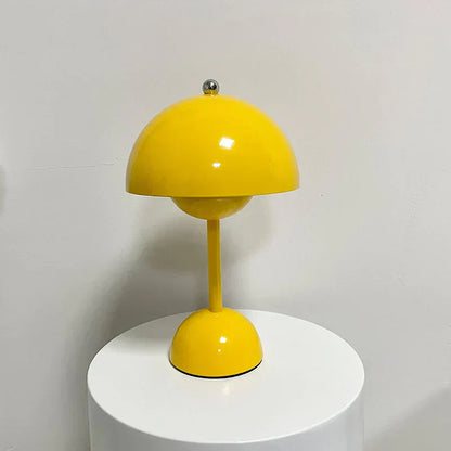 Glänzende gelbe Tischlampe auf weißem Sockel