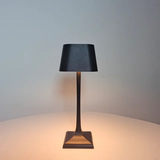 Schwarze LED-Tischlampe mit konischem Sockel im dunklen Raum