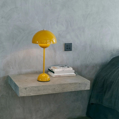 Gelbe Designlampe auf grauer Kommode mit Buch