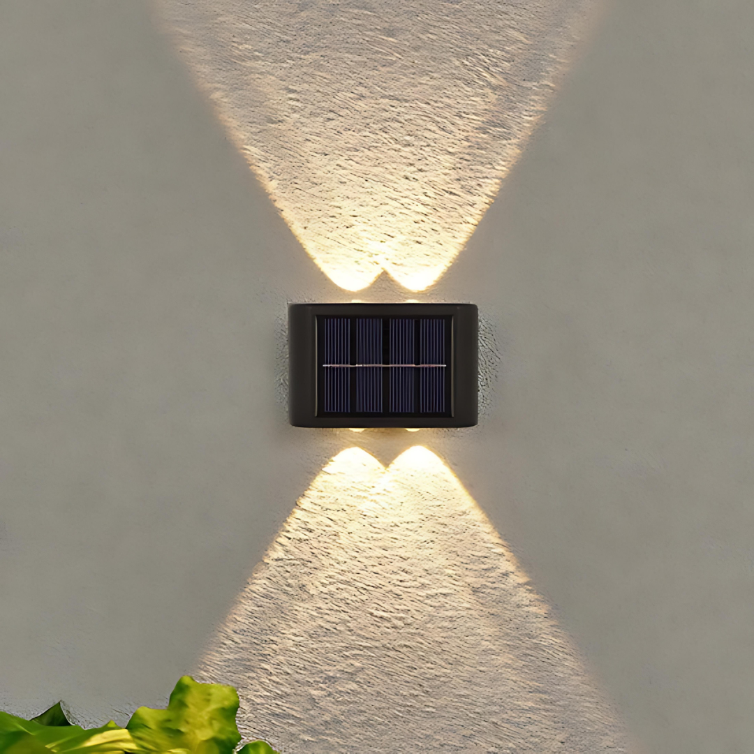 Einzelne LED-Solarwandleuchte mit Licht nach oben und unten an weißer Außenwand