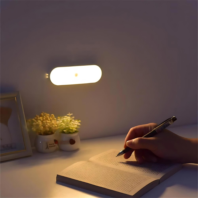 LED-Nachtlicht an der Wand über Tisch mit Blumen und Hand, die schreibt

